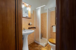 A bathroom with a white sink, a wooden toilet, and a glass shower enclosure. - Farmhouse "Roccia" with Shared Pool, Private Terrace & Wi-Fi (Pitigliano)