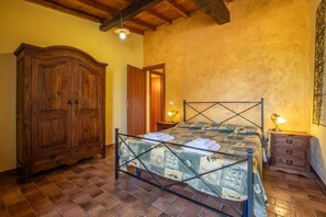 Une chambre à coucher avec un lit, une armoire en bois et une table de chevet.