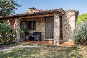 Une maison en pierre dotée d’un patio, d’un extincteur et d’un espace salon abrité.