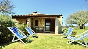 A stone building with a tiled roof, two windows, and a door. There are two striped lounge chairs in front. - Farmhouse "Sasso Bianco" with Shared Pool, Private Terrace & Wi-Fi (Pitigliano)