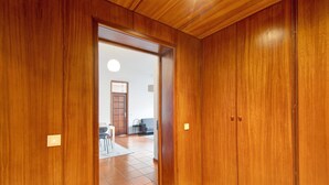 Een houten garderobe met een deur naar een woonruimte.