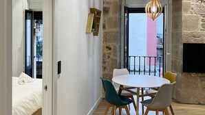 Un espace de salle à manger moderne avec un mur d’accent en pierre, une table ronde et des chaises.