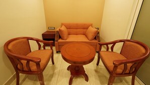 Una habitación con una mesa de madera y dos sillas, un sofá y una mesita auxiliar.