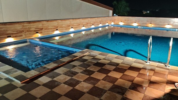 Una piscina con piso a cuadros y pared de madera.