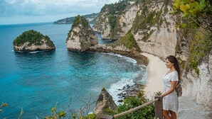 Vista costera con acantilados rocosos y una playa.