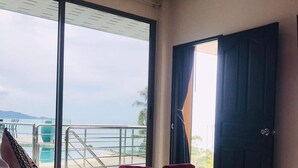 A hotel room with a bed, a view of the sea, and a balcony.