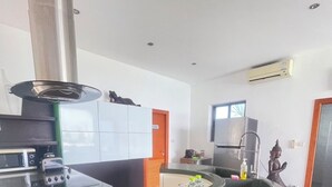 A modern kitchen with a central island, a built-in oven, and a stainless steel range hood.