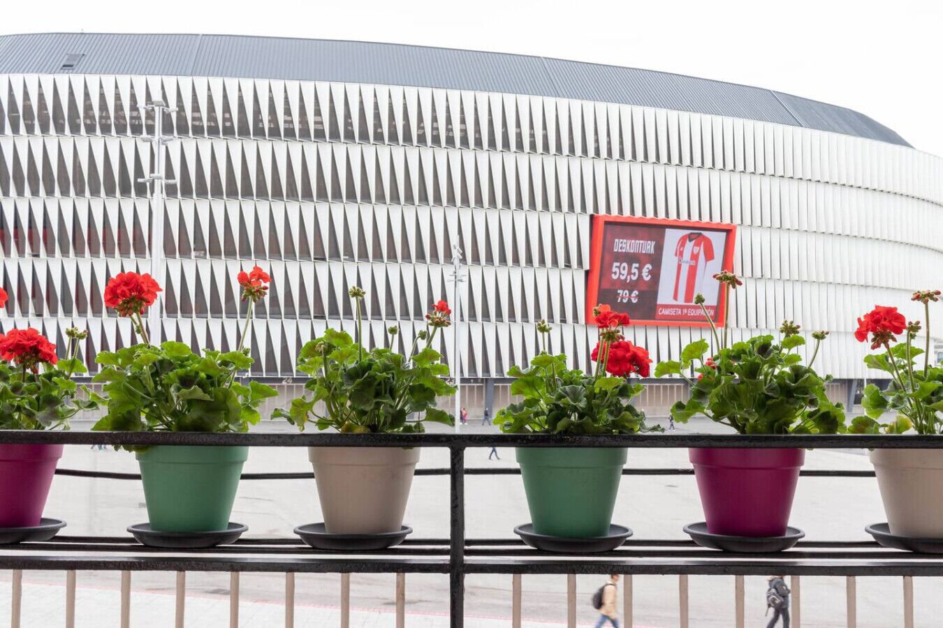 Un edificio moderno con fachada curva y un anuncio que ofrece descuento en productos.