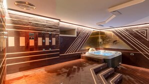 Un baño moderno con hidromasaje, suelo de mármol y diseño de pared de piedra.
