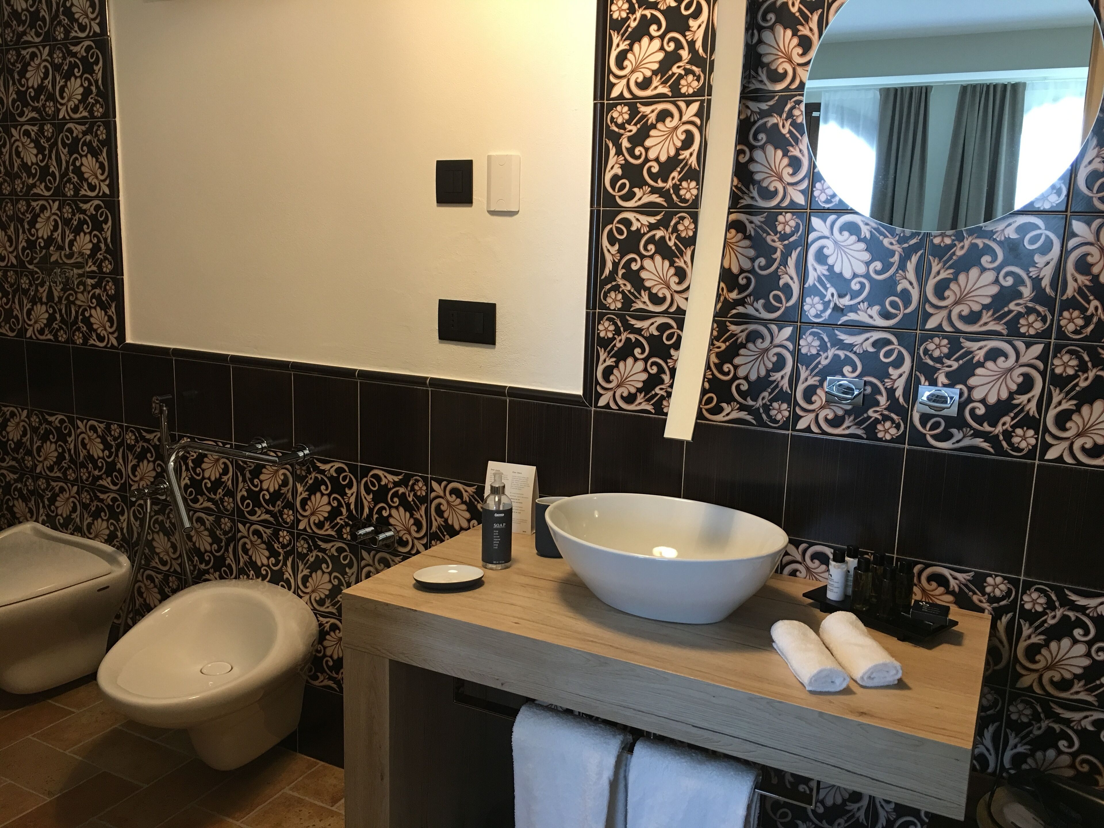 A bathroom with a large sink, two urinals, a toilet, and a mirror.