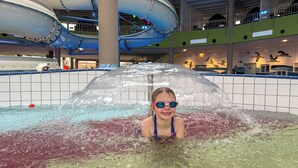 A person in a pool with a water slide structure overhead. - Ferienwohnung mit Balkon - Hunde Willkommen Wiesengeflüster (Röbel/Müritz)
