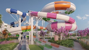 A water park with multiple slides in various colors, surrounded by greenery and flowers. - Vor5550aa: 5 Bed, Imagination Lab, Pool (Orlando)