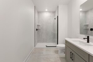 Ein modernes Badezimmer mit Dusche, Toilette und Waschtisch.