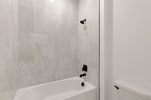 Ein modernes Badezimmer mit einer Badewanne, einer Dusche und einem WC.
