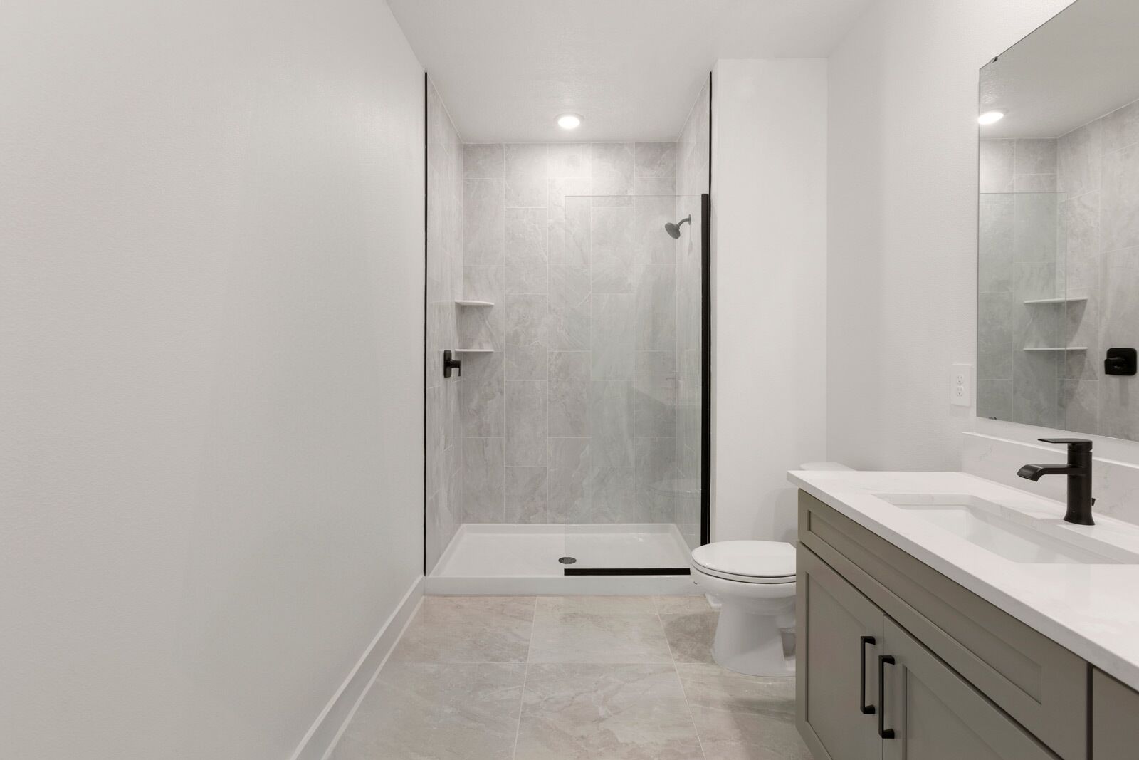 A modern bathroom with a shower, toilet, and vanity.