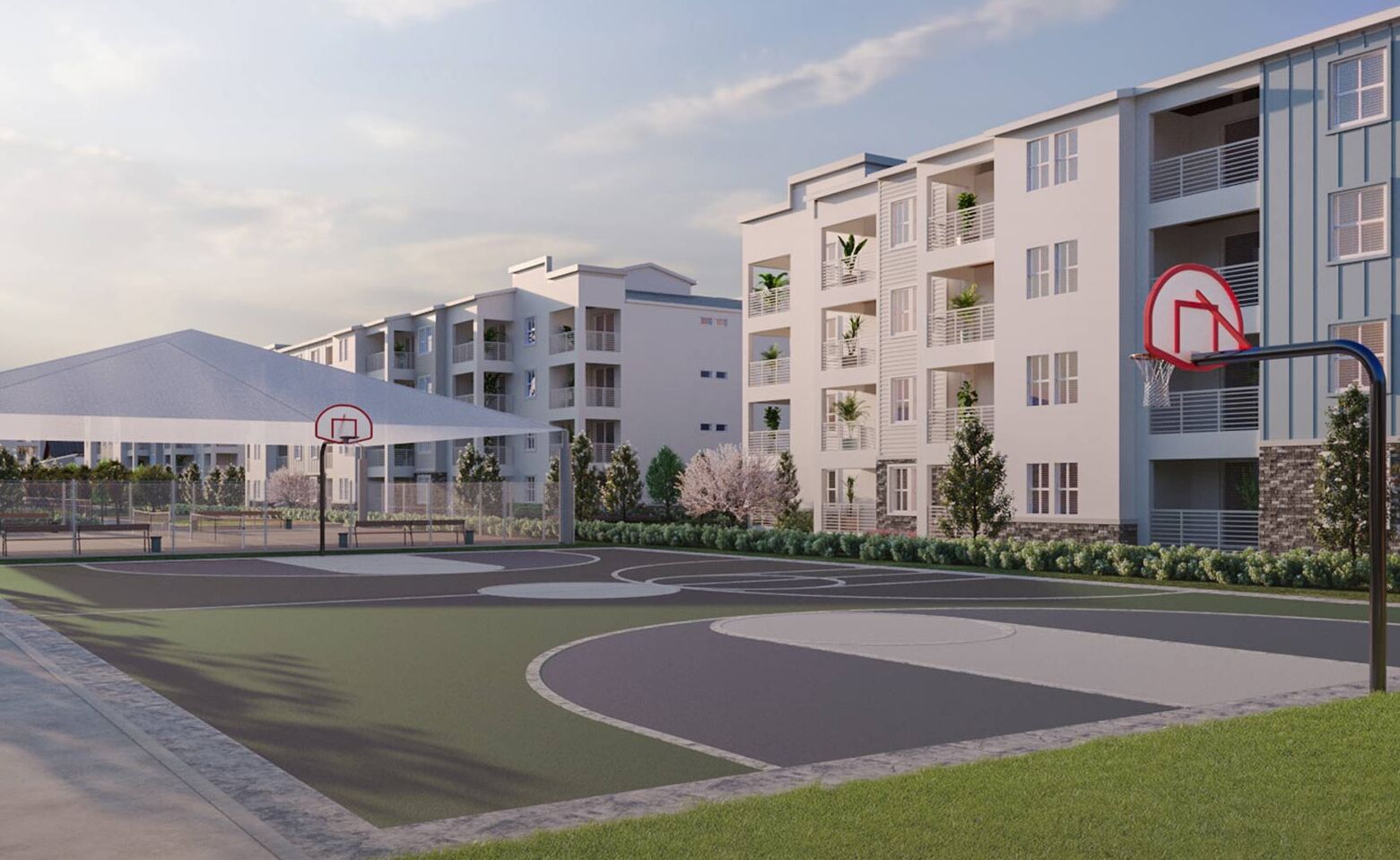 A modern residential building with multiple balconies, a basketball court, and a covered seating area.
