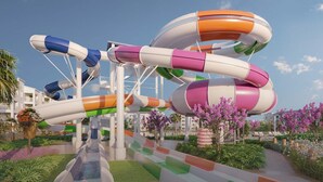 A water park with multiple colorful slides and a pathway lined with greenery and flowers. - Vor5363aa: 5 Bed, Imagination Lab, Pool (Orlando)