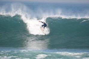 Een surfer die een hoge golf berijdt.
