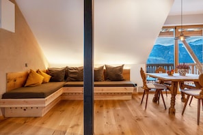 Una camera da letto in stile loft con una panca in legno integrata e un'area pranzo con tavolo e sedie in legno.