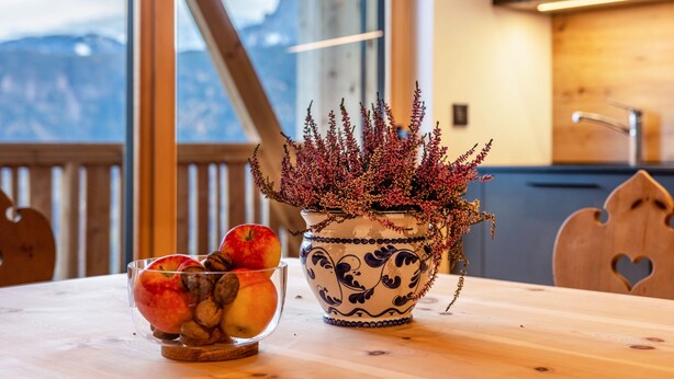 A wooden table with a bowl of fruit and a decorative vase. - Apartment 'Rotwandterhof Bienenstock' with Mountain View, Shared Garden and Wi-Fi (Lengstein)