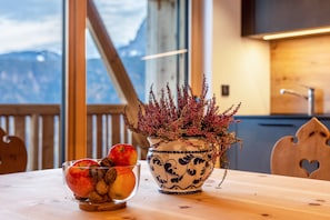 A wooden table with a bowl of fruit and a decorative vase.