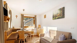 Una sala acogedora con sofá, mesa de comedor y banca.