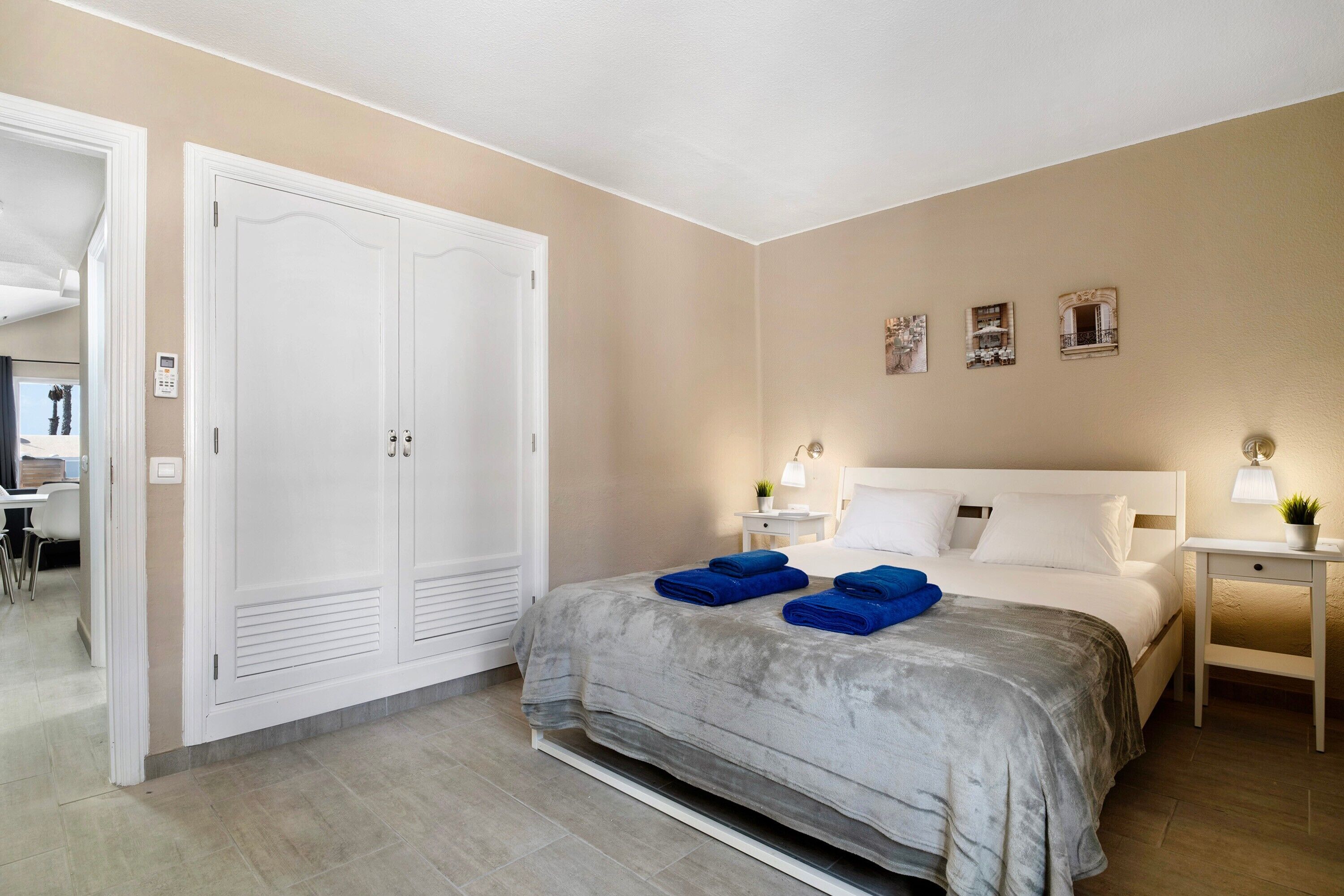 A bedroom with a bed, bedside tables, a wardrobe, and a desk with a chair.