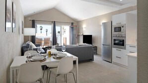 Eine moderne Küche mit Essbereich, einer Couch und einem Fernseher.