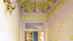 Eine prächtige Treppe mit aufwendigen floralen Wandverzierungen und einem Chandelier.