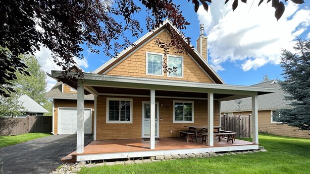 A two-story house with a covered porch, a garage, and a well-maintained lawn. - Inviting Family Retreat w/Hot Tub in Driggs (Driggs)