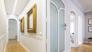 A hallway with wooden parquet flooring, white walls, and three golden-framed mirrors. - Contemporary apartment in Valencia city center with Wifi and air conditioning (Valencia)