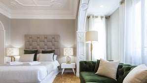 A hotel room with a large bed, a green sofa, and two bedside tables with lamps. - Contemporary apartment in Valencia city center with Wifi and air conditioning (Valencia)
