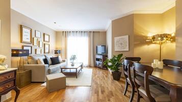 Una sala de estar moderna con sofá, mesa de centro y zona de comedor.