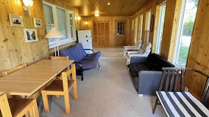 Un acogedor interior de cabaña con una mesa de comedor de madera, un sofá y un banco.