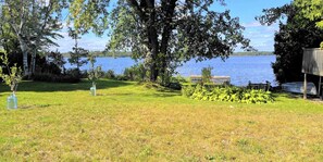 Un área verde con un muelle y una pequeña estructura junto a un lago.