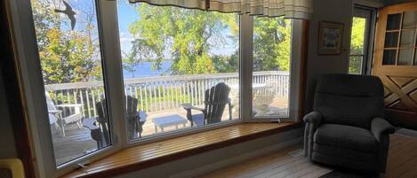 A room with large windows overlooking a deck with outdoor furniture.