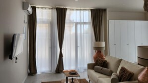 Un salon moderne avec un canapé, une table basse et une lampe.