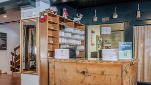 A reception desk with a wooden design, a sign for WiFi, and a holiday sign.