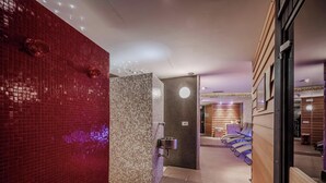A hallway with a red tiled wall, a tiled shower area, and a seating area with a wooden wall and a mirror.