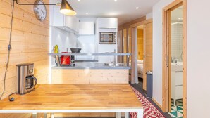 A modern kitchen with wooden accents, a built-in oven, and a sink. - Cozy 2-room apartment in Avoriaz with fireplace, south-facing balcony (Avoriaz)