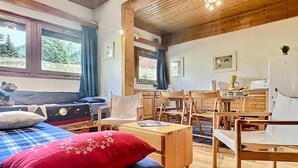 A cozy room with a bed, a desk, and a dining area. - Spacious 2BR in Val d'Isère with Two Bathrooms (Val-d'Isère)