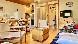 A cozy room with a bed, a desk, a chair, a small table, a television, and a teddy bear. - Spacious 2BR in Val d'Isère with Two Bathrooms (Val-d'Isère)