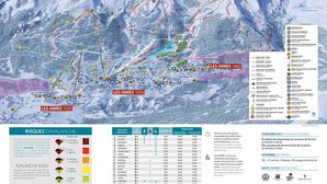 Een overzichtskaart van een ski-resort met aangegeven pistes, skiliften en bergtoppen.