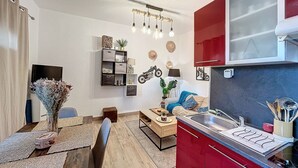 A compact living space with a kitchenette, a dining area, and a seating area.