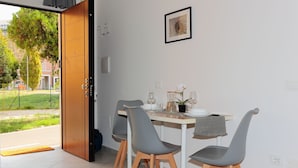 A dining area with a table set for four, chairs, a vase with flowers, and a framed picture on the wall. - La Cà Fiera 11E. (Bologna)