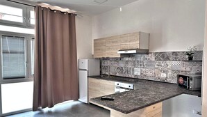 Una cucina moderna con forno a microonde integrato, frigorifero e lavello.