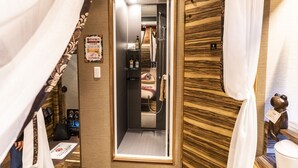 A hotel bathroom with a mirror, a shower, and a towel rack. - Petit Bali Forest Shinjuku Sanchome (Tokyo)