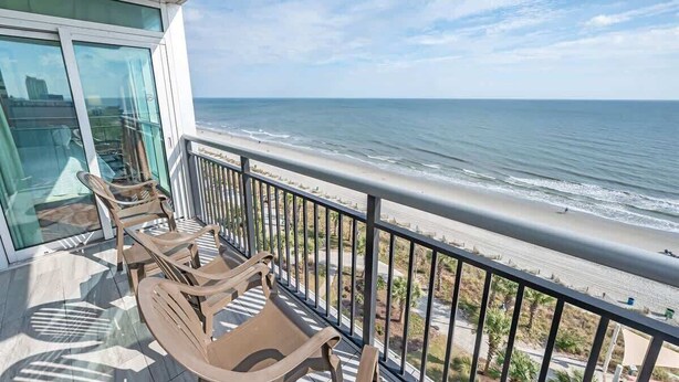 Un balcon avec vue sur la plage et l’océan.