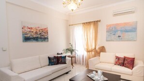 Ein modernes Wohnzimmer mit zwei Sofas, einem Couchtisch und Kunstwerken an den Wänden.