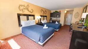A hotel room with two beds, a desk, a chair, a small kitchenette, and decorative wall art. - New Landmark Resort Great Pools with Waterpark View (Myrtle Beach)